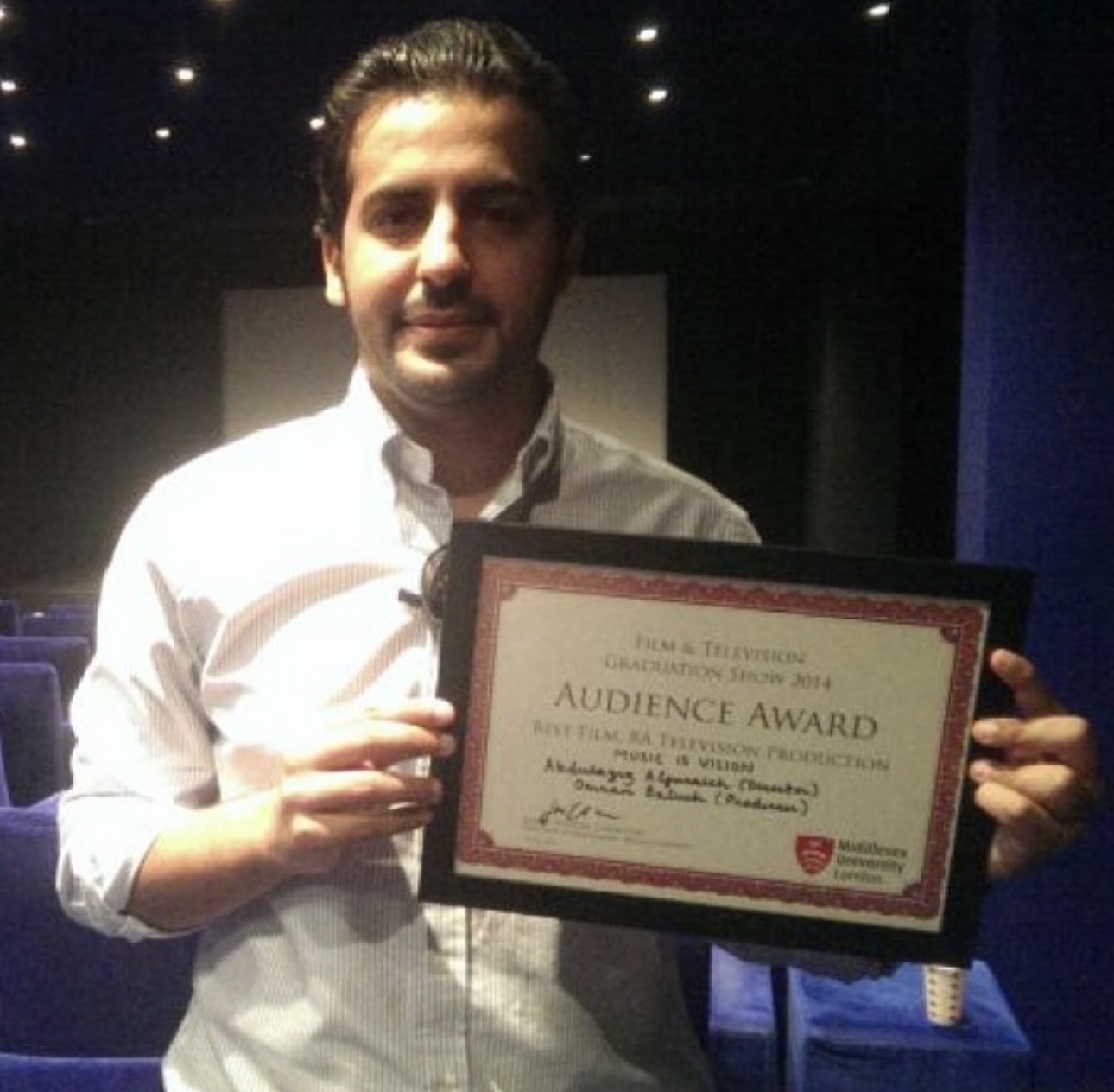 Abdulaziz Alfuraih holding a certificate of recognition at Middlesex University