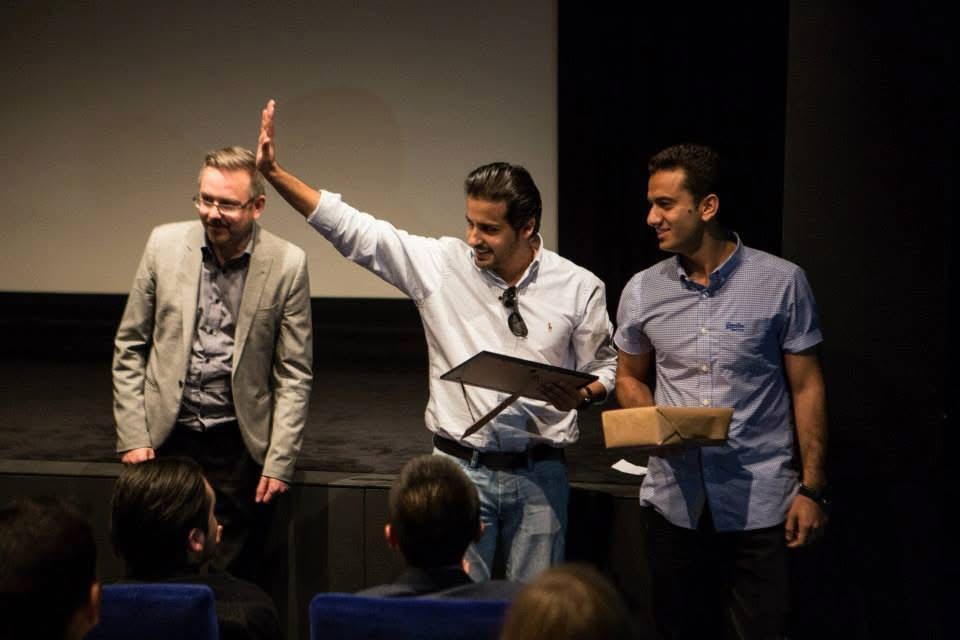 Abdulaziz Alfuraih receiving a certificate on stage at Middlesex University